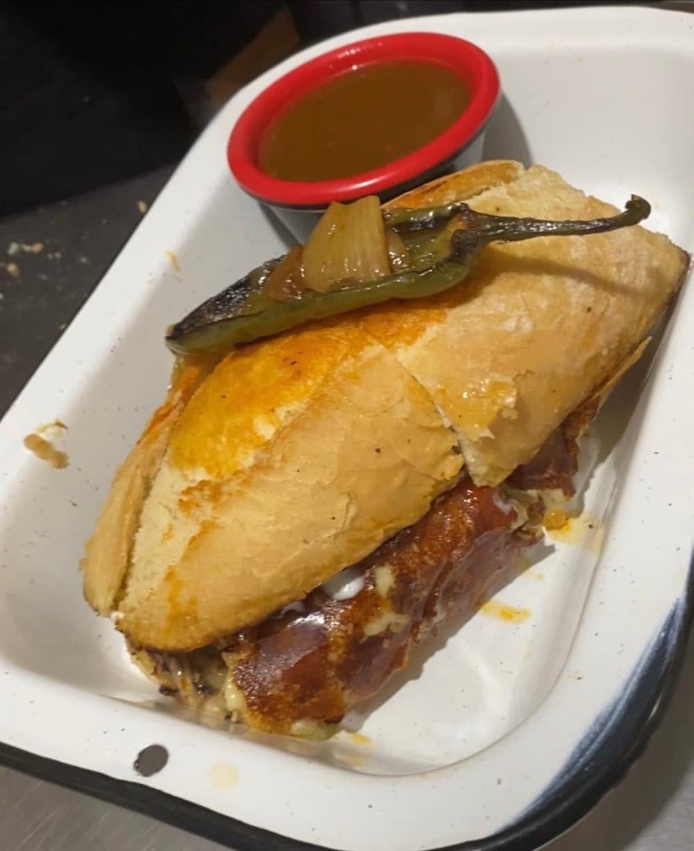 Lonche de birria en birote con chile toreado y consomé al lado